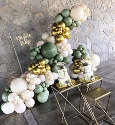 a table with balloons and cake on it in front of a stone wall that says mulits d'oro