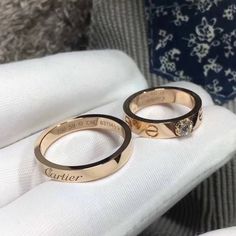 two gold wedding rings sitting on top of each other