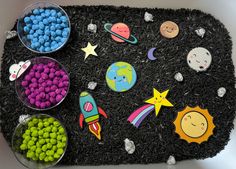 there are many different items on the black mat that is made to look like an outer space theme