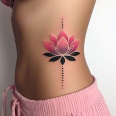 a woman's stomach with a pink flower tattoo on her lower back and side