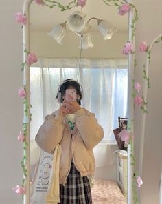 a woman taking a selfie in front of a mirror with pink flowers on it