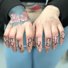 two hands with tattoos on their fingers and the words believe