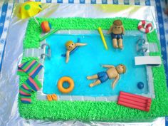 a cake that is shaped to look like a swimming pool with people in the water