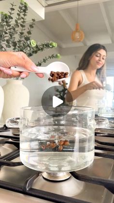 two women are cooking food on the stove in the kitchen and one woman is holding a spoon