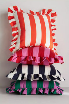 four pillows stacked on top of each other with different colored ruffles around them