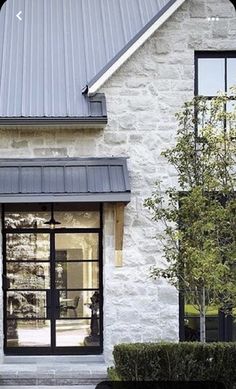 a white brick house with black trim and windows