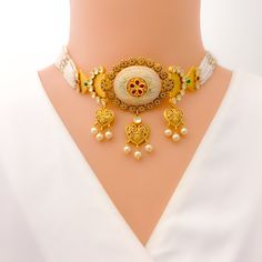 This 22k gold necklace set, weighing 62.1 grams, showcases an imperial and classy floral design with an antique finish, adorned with Kundan and pearl accents. The necklace measures 17 inches in length with a 1.25-inch drop and includes 0.8-inch adjustable links, secured with a hook lock. The set includes matching earrings, each 1.6 inches in length with a screw back post. Ideal for those who appreciate luxurious and timeless jewelry, this set combines the regal elegance of antique gold with the traditional beauty of Kundan and pearls, making it a standout piece perfect for enhancing your personal style. PRODUCT DETAILS Gold Purity(karat): 22k Item Weight(grams): 62.1 Item Finish: Antique Finish Stone: Kundan + Pearl Set Length: 17" Drop Length: 1.25" Adjustable Links: 0.8" Links Lock Style Formal 22k Gold Meenakari Temple Necklace, Ornate Gold Necklace For Reception, Traditional 22k Gold Necklaces For Receptions, Elegant 22k Gold Choker For Wedding, Elegant 22k Gold Wedding Choker, Gold Traditional Pearl Necklace For Reception, Traditional 22k Yellow Gold Pearl Necklace, Elegant 22k Gold Pearl Necklace With Meenakari, Elegant 22k Gold Choker