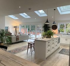 a large open kitchen and living room with skylights