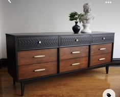 a black and brown dresser sitting on top of a hard wood floor