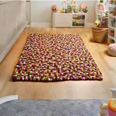 a child's room with a rug made out of colorful balls on the floor