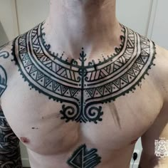 a man with tattoos on his chest and chest