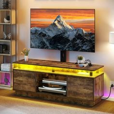 a flat screen tv sitting on top of a wooden entertainment center in a living room