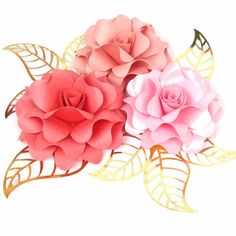 three paper flowers with gold leaves and pink one on the left side, in front of a white background