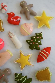 felt christmas ornaments are arranged on a marble surface