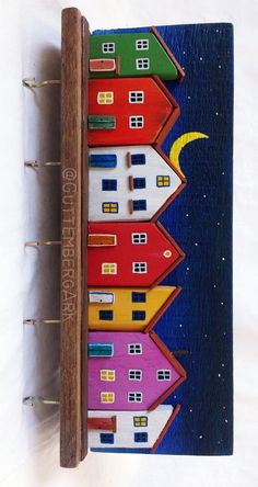 a small wooden book with houses painted on it