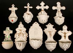 an assortment of white crucifixs and crosses are displayed on a black background