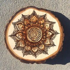 a wooden slice with an intricate design on it's side, sitting on the ground