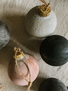 three different colored balls are sitting on the ground next to some twine string and rope