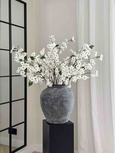 a vase filled with white flowers sitting on top of a table