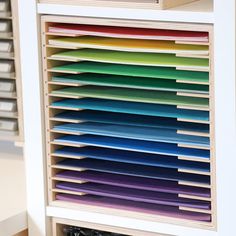 the drawers are filled with many different colored papers