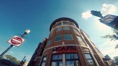 the sun shines brightly in front of a brick building on a city street corner