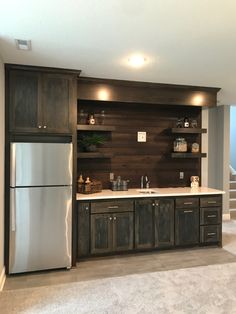 a kitchen with wood paneling and stainless steel refrigerator freezer combo in the center