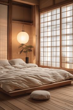 a large bed sitting inside of a bedroom next to two windows