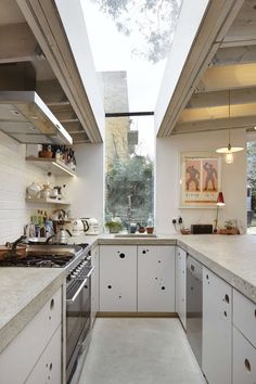 an open kitchen with white cabinets and stainless steel appliances, is shown in this image