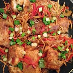 a pan filled with chicken and veggies on top of a stove