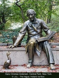 a statue of a man sitting on top of a bench next to a bird