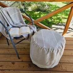 a chair and ottoman on a deck with an open book in the middle of it