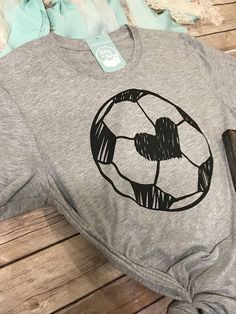 a shirt with a soccer ball drawn on it sitting on top of a wooden floor