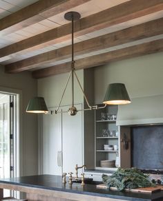 a kitchen island with two lights hanging from it's ceiling and an oven in the background