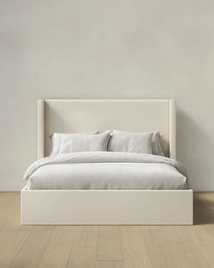 a white bed sitting on top of a wooden floor