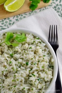 a white bowl filled with rice and garnished with cilantro