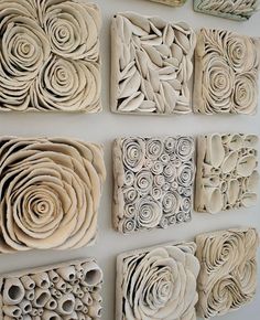 several pieces of art made out of clay sitting on a wall