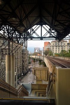 an overhead view of a train station with people on the platform and buildings in the background