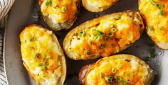 baked potatoes with cheese and green onions on a plate