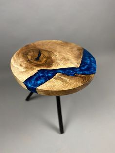 a wooden table topped with a blue ribbon on top of it's legs and an object in the background