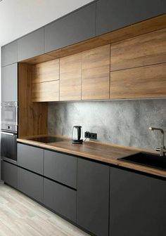 a kitchen with black cabinets and wooden counter tops, along with a stainless steel dishwasher