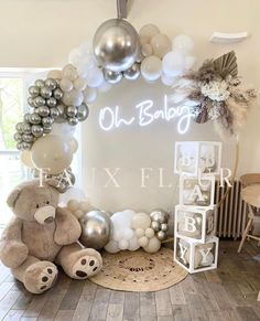 balloons and teddy bears are arranged on the floor in front of a sign that reads oh baby