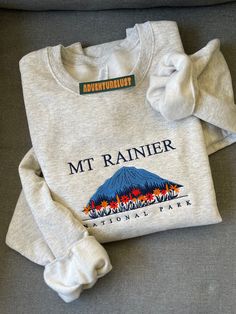 - Mount Rainier National Park Embroidered Hoodie - Perfect gift for nature lovers, adventurers, or anyone who loves National Parks.  - Fabrication - Heathered grey color crewneck - 70/20 cotton/poly blend - Size is unisex - Care Instructions - Turn inside out and machine wash cold on delicate cycle - Dry on low heat setting - Do not bleach or dry clean - Processing and Shipping Times - Please allow 3-5 business days for your order to be processed and stitched - Standard shipping takes 3-5 days - State Embroidery, Clothing Board, National Park Gifts, Womens Hats, Garden Grove, Mount Rainier National Park, Rainier National Park, Granola Girl, Embroidery Sweatshirt