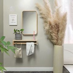 a bathroom with a plant and mirror on the wall