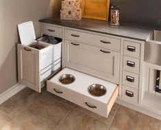 an open drawer in the kitchen with two bowls and one bowl on it's side