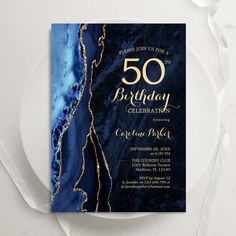 a blue and gold 50th birthday party card on a plate