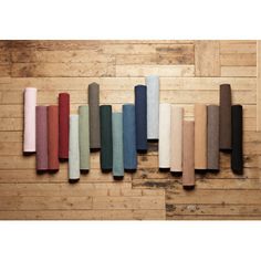 a row of different colored rugs sitting on top of a wooden floor