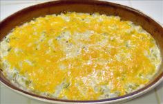 a casserole dish with cheese and broccoli in it on a stove