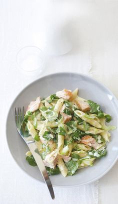 a white plate topped with pasta and greens