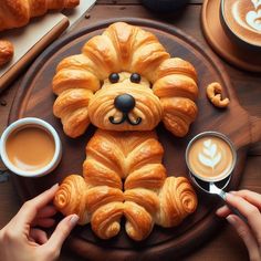 there is a croissant shaped like a dog on the table with coffee and pastries