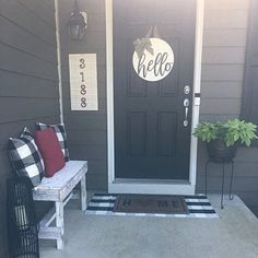 a black and white front door with red pillows